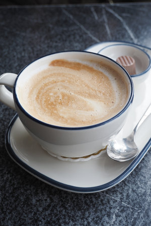 Enjoying a warm cup of coffee in a cozy cafeの写真素材