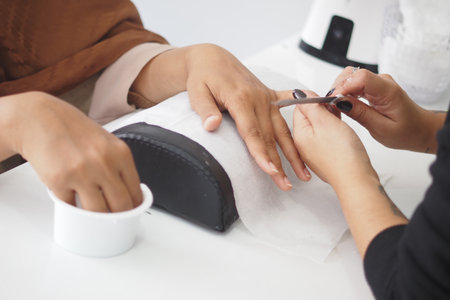 Nail technician offers manicure to a client in a salonの写真素材