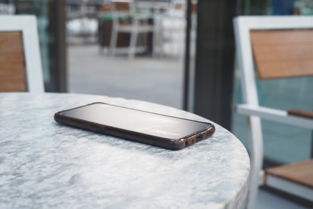 Smartphone resting on a table in a cafe setting. lost smart phone conceptの写真素材