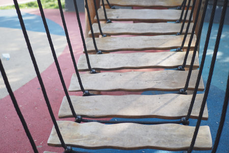 Wooden bridge in a playground during daytime explorationの写真素材