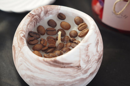 Unique candle with coffee beans in artistic holderの写真素材