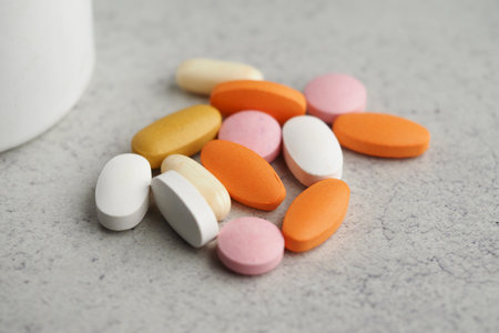 Various colorful vitamins and supplements on a gray surfaceの写真素材