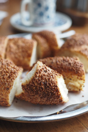 Freshly baked sesame bread rolls on a silver trayの写真素材