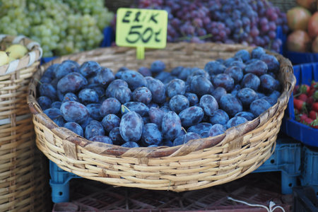 Fresh plums in a basket at a local marketの写真素材
