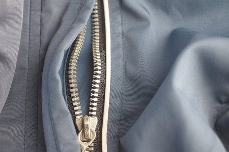 Close-up of a zipper on a blue fabric jacketの写真素材