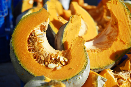 Freshly cut pumpkin pieces at a local marketの写真素材