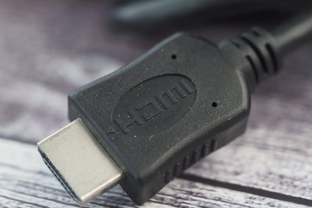 Close-up of a black HDMI cable connector on a wooden surface