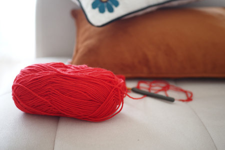 Yarn and crochet hook on a cozy sofa setupの写真素材