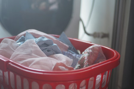 Laundry basket filled with clean clothes at homeの写真素材