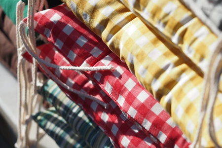 Colorful cushions displayed at a market stall in daylightの写真素材