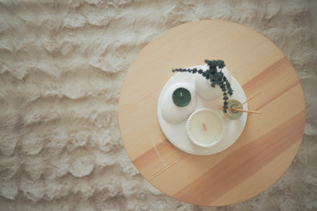 Decorative candles and plants arranged on a wooden tableの写真素材