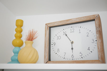 Bright home decor featuring a clock and vases on a shelf