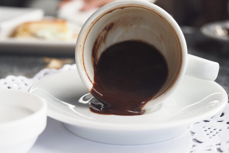 Empty coffee cup on a white saucer with brown residue