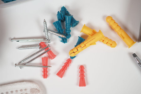Colorful screws and anchors arranged on a white surface