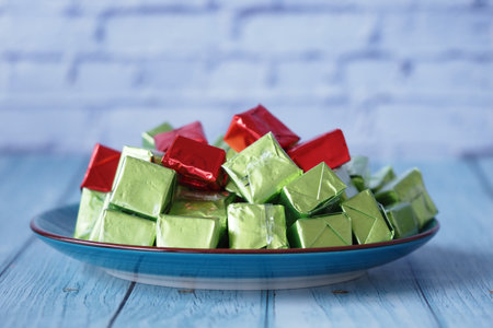 Colorful candy squares arranged on a blue plateの写真素材
