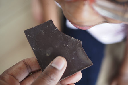 Child tasting chocolate in a casual indoor setting