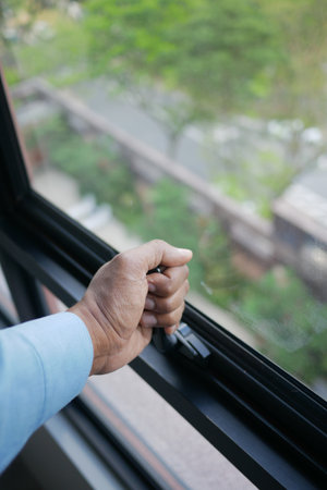 Hand opening window to enjoy fresh air and natureの写真素材