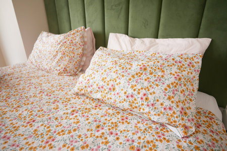 Floral bedding adorns a cozy bedroom with green accents