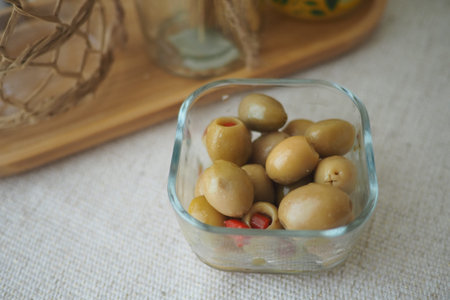 Different varieties of olives in a glass dish on a tableの写真素材