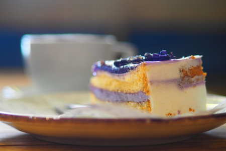 Colorful cake slice with cup on a wooden table