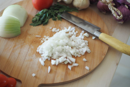Chopping onions and fresh vegetables on a wooden board