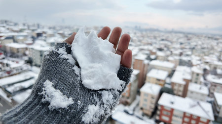 Snow in hand with city skyline in winter seasonの写真素材