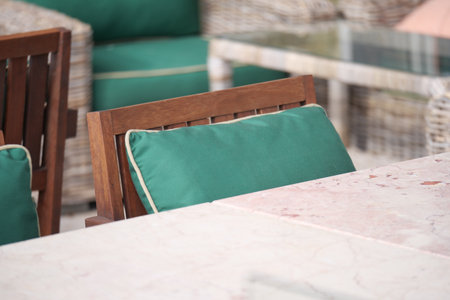 Outdoor seating area with green cushions and marble tableの写真素材