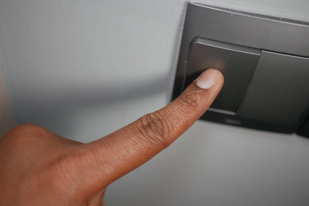 Finger pressing a light switch in a home setting