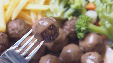Delicious meatballs served with vegetables and friesの写真素材