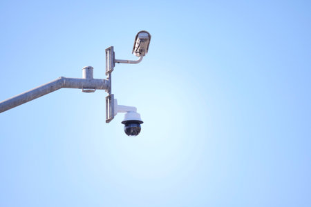 Security camera monitors area under clear blue skyの写真素材