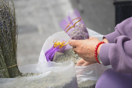 Woman preparing lavender sachets in market settingの写真素材