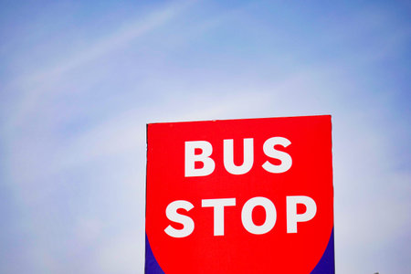 Bus stop sign against clear blue sky
