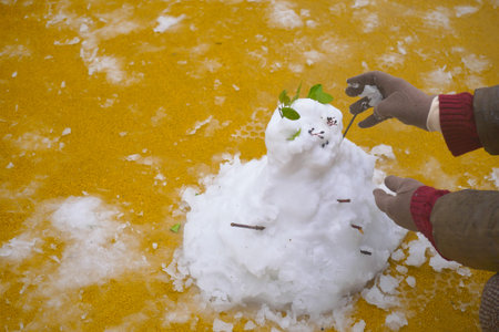 Building a snowman in a colorful winter wonderlandの写真素材