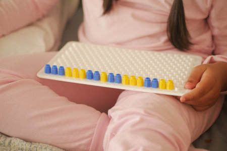 Child playing with colorful counting beads at homeの写真素材
