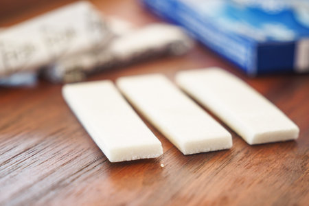 Chewing gum pieces on a wooden table near a blue box