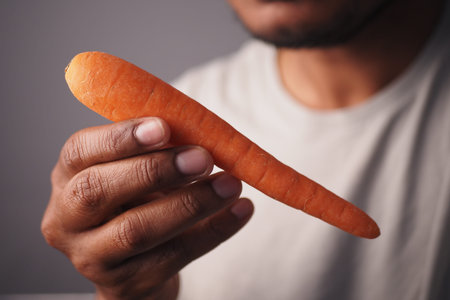 Holding a fresh carrot in a casual setting