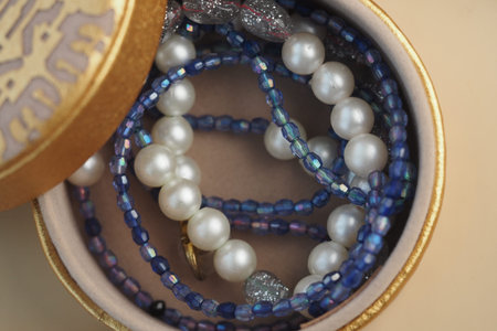 Colorful beads in a decorative box on a neutral background