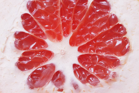 Close view of a sliced grapefruit revealing juicy segments