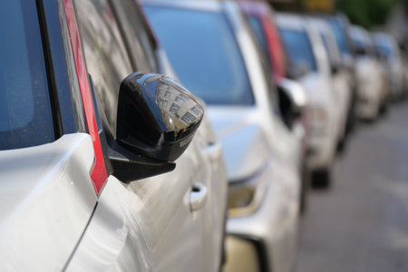 Cars parked closely along a city street in the afternoonの写真素材