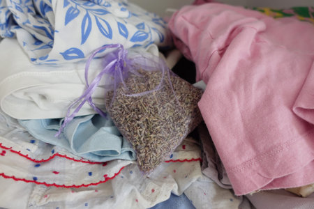 Lavender sachet among neatly folded clothes in a bedroom
