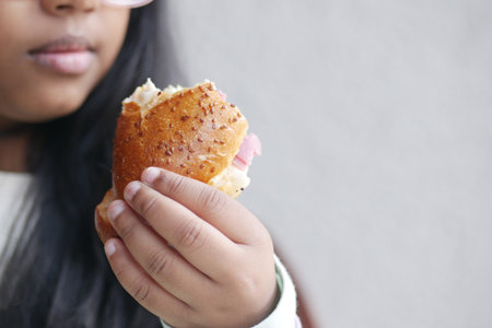 Child enjoying a sandwich in a casual settingの写真素材