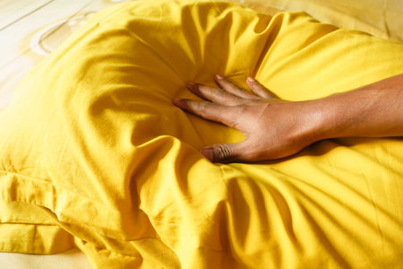 Soft yellow cushion being pressed with a handの写真素材