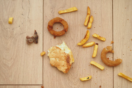 Food remnants scattered on wooden floor after mealの写真素材
