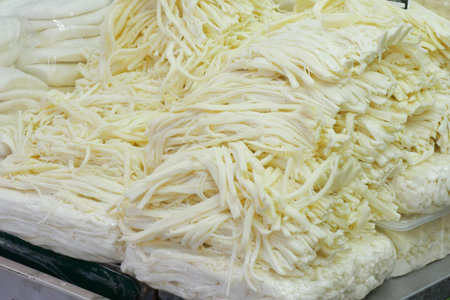 Freshly prepared cheese strands at a market stall in summerの写真素材