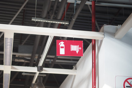 Sign hanging from ceiling showing fire extinguisher and hose symbols