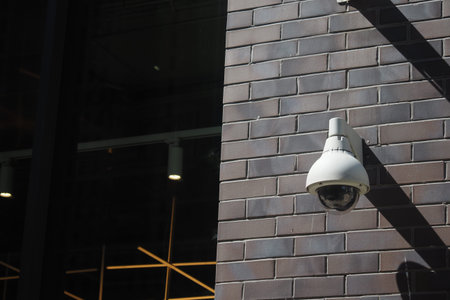 Security camera mounted on a brick wall in urban area
