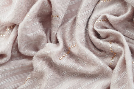 Soft pink fabric draped with delicate embellishments