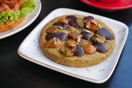 Delicious cookies with nuts and caramel on a white plate