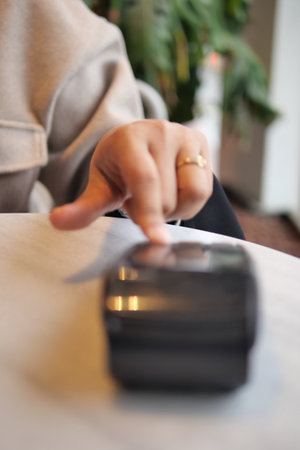 Close-up of a hand using a touchscreen payment deviceの写真素材