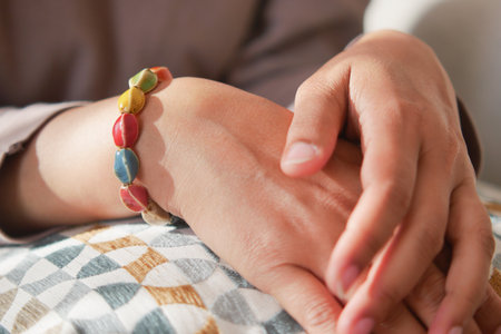 Colorful bracelet worn by a person resting at homeの写真素材